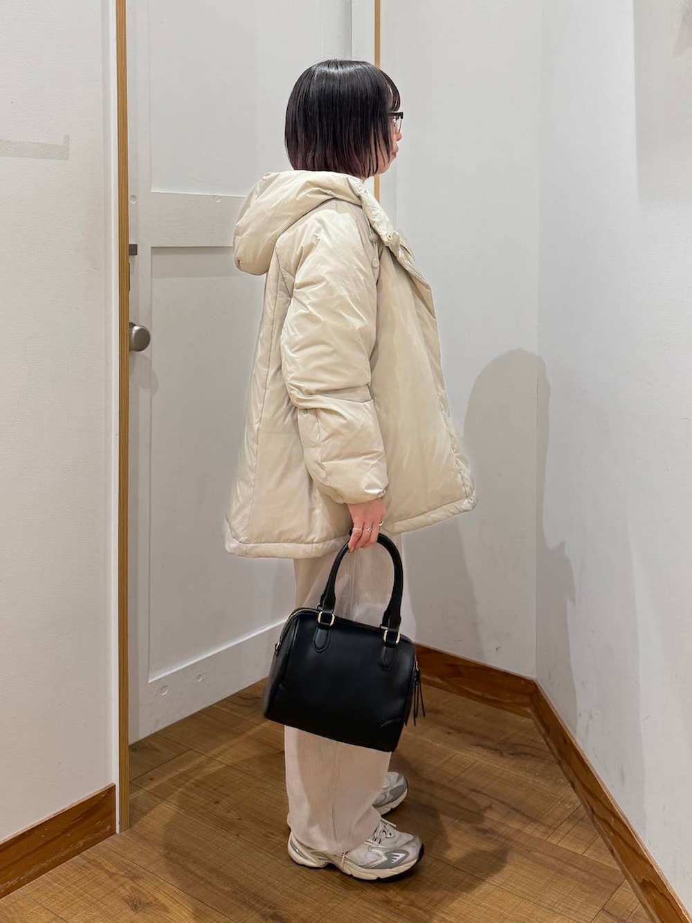 ベージュ系のダウンジャケット/コート、グレー系のその他パンツ、ホワイト系のTシャツ/カットソーを着用したレディースの冬コーディネートの4枚目の写真