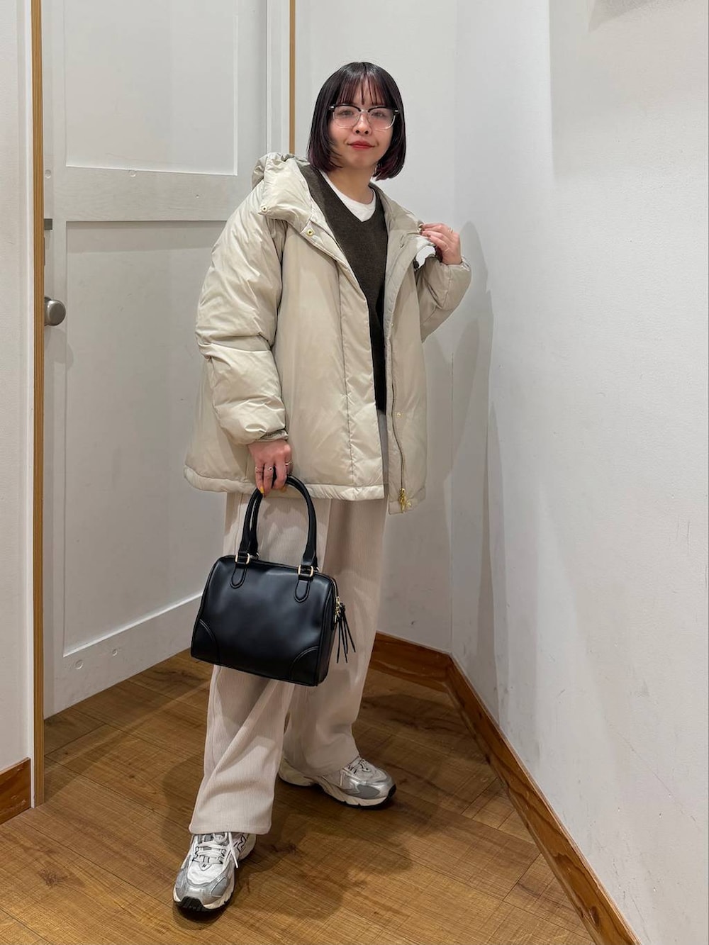 ベージュ系のダウンジャケット/コート、グレー系のその他パンツ、ホワイト系のTシャツ/カットソーを着用したレディースの冬コーディネートの3枚目の写真