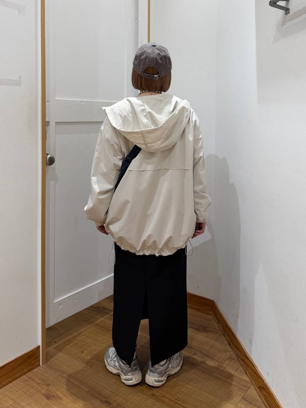 グレー系のスウェット、ベージュ系のマウンテンパーカー、グリーン系のショルダーバッグを着用したレディースの冬コーディネートの4枚目の写真