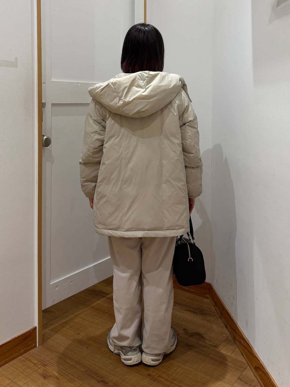 ベージュ系のダウンジャケット/コート、グレー系のその他パンツ、ホワイト系のTシャツ/カットソーを着用したレディースの冬コーディネートの5枚目の写真