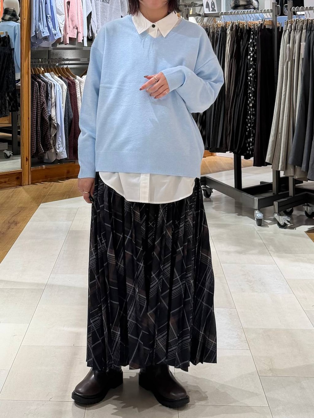 ホワイト系のシャツ/ブラウス、ブラウン系のブーツ、ブルー系のニット/セーターを着用したレディースの冬コーディネートの2枚目の写真