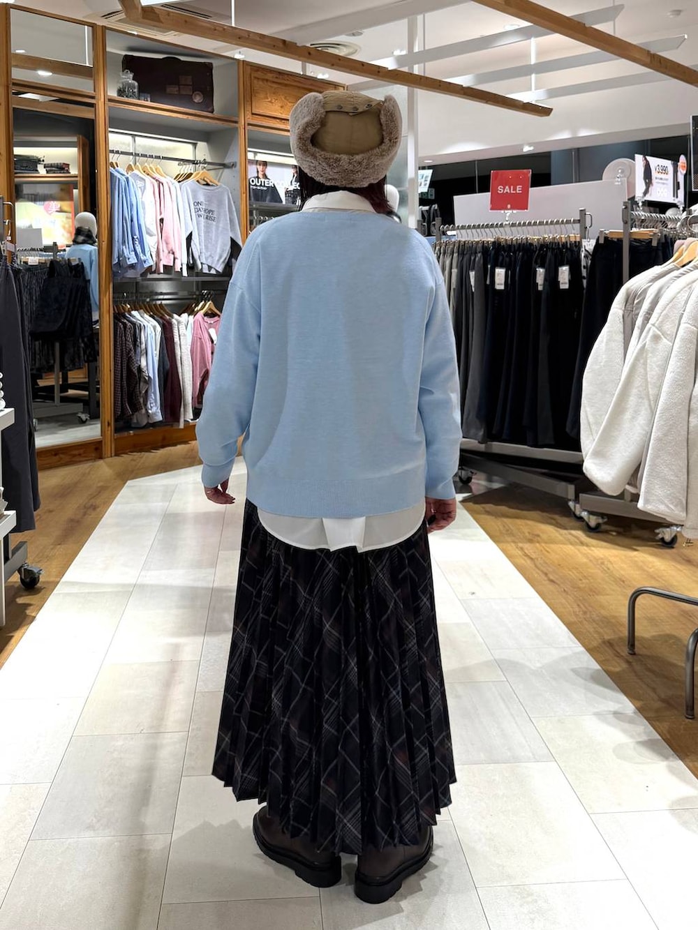 ホワイト系のシャツ/ブラウス、ブラウン系のブーツ、ブルー系のニット/セーターを着用したレディースの冬コーディネートの4枚目の写真