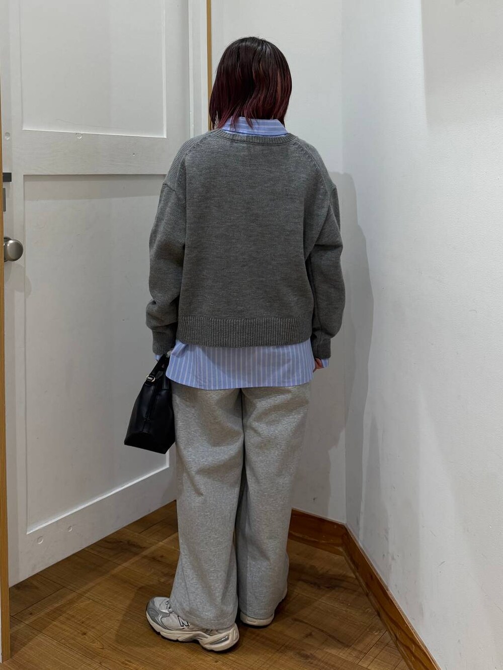 ブラック系のショルダーバッグ、グレー系のスウェットパンツを着用したレディースの冬コーディネートの4枚目の写真