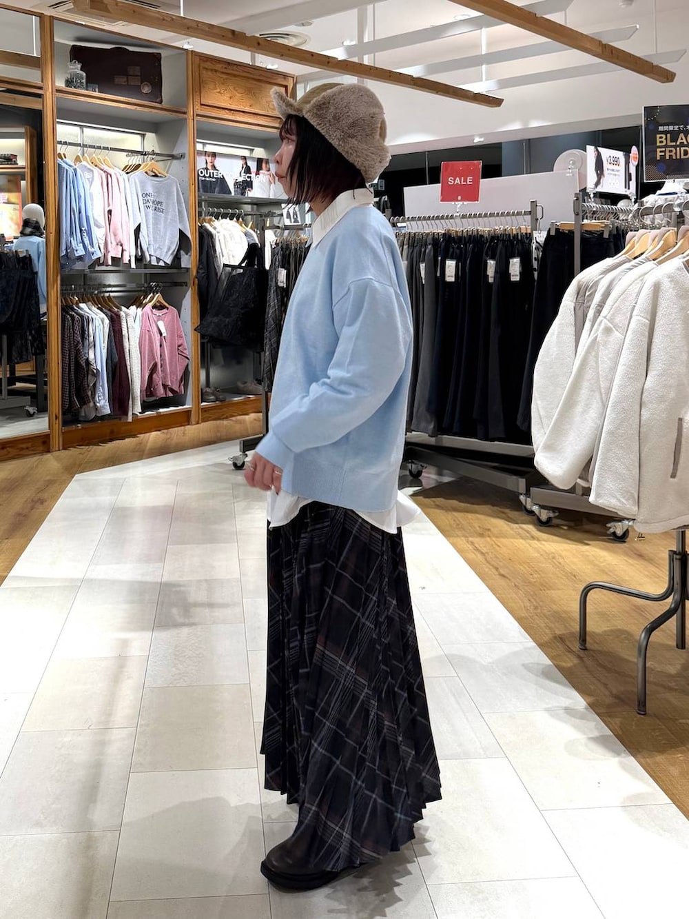 ホワイト系のシャツ/ブラウス、ブラウン系のブーツ、ブルー系のニット/セーターを着用したレディースの冬コーディネートの3枚目の写真