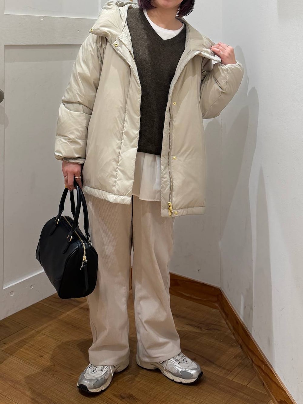 ベージュ系のダウンジャケット/コート、グレー系のその他パンツ、ホワイト系のTシャツ/カットソーを着用したレディースの冬コーディネートの2枚目の写真