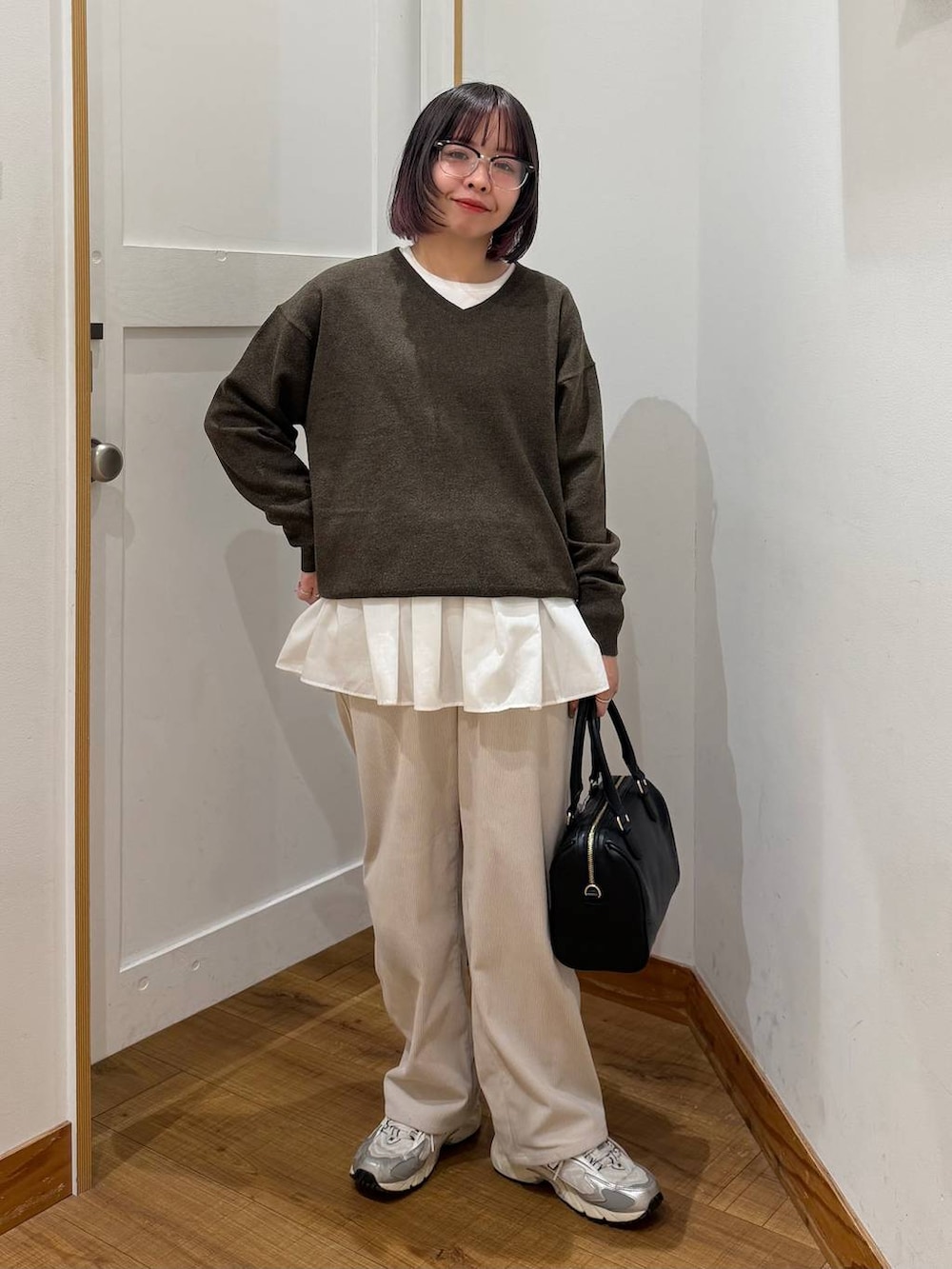 ベージュ系のダウンジャケット/コート、グレー系のその他パンツ、ホワイト系のTシャツ/カットソーを着用したレディースの冬コーディネートの7枚目の写真