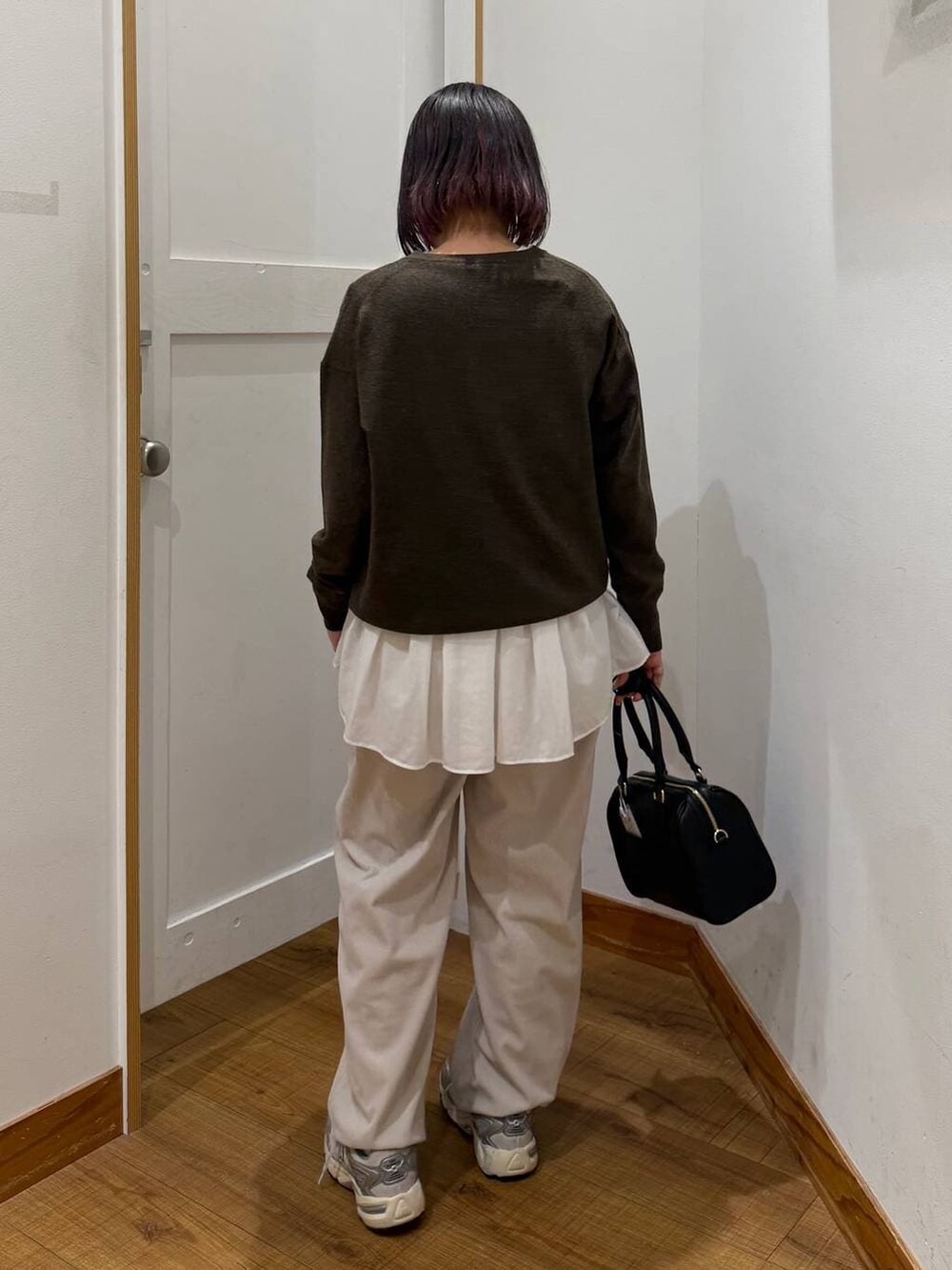 ベージュ系のダウンジャケット/コート、グレー系のその他パンツ、ホワイト系のTシャツ/カットソーを着用したレディースの冬コーディネートの8枚目の写真