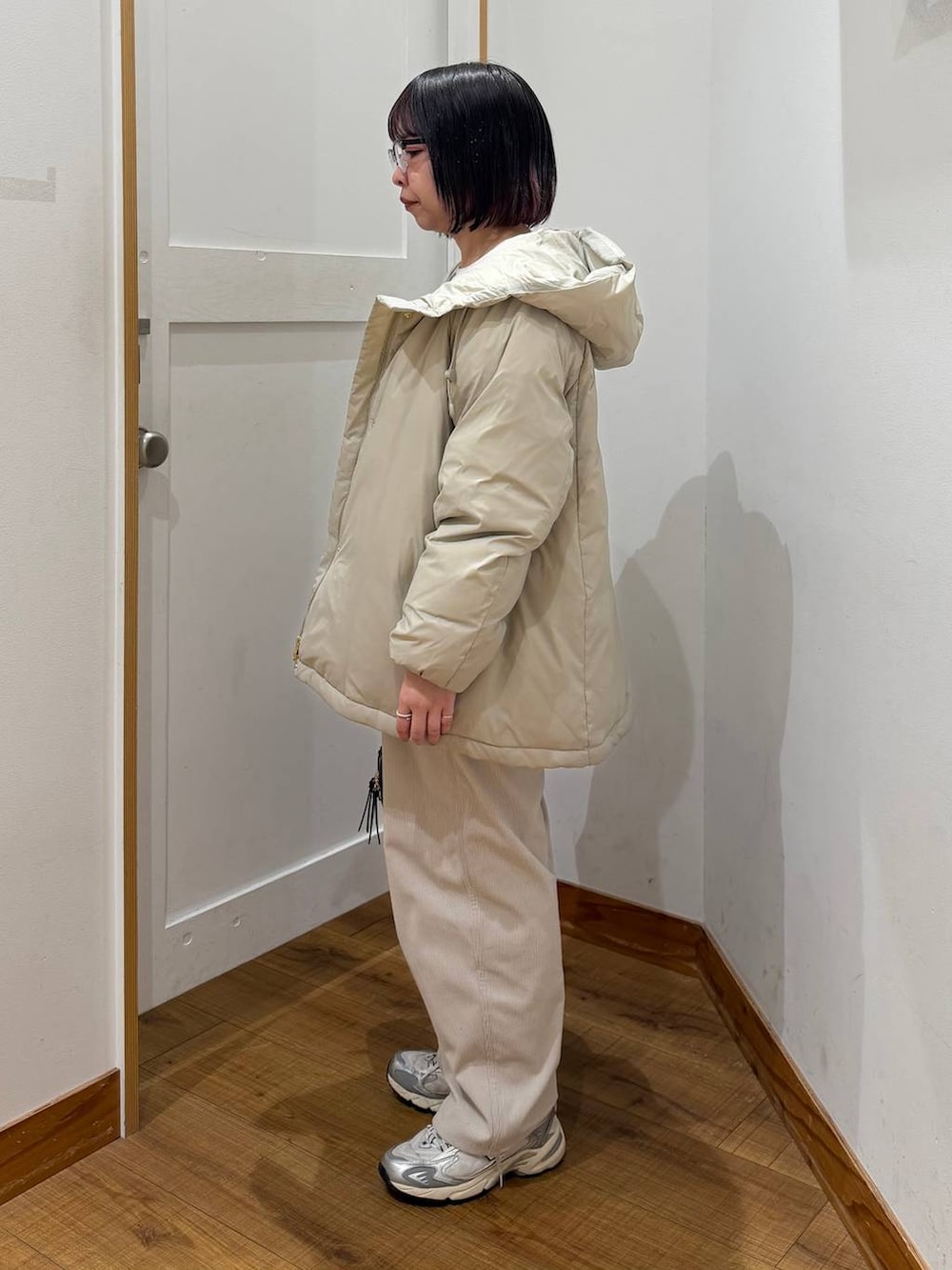 ベージュ系のダウンジャケット/コート、グレー系のその他パンツ、ホワイト系のTシャツ/カットソーを着用したレディースの冬コーディネートの6枚目の写真