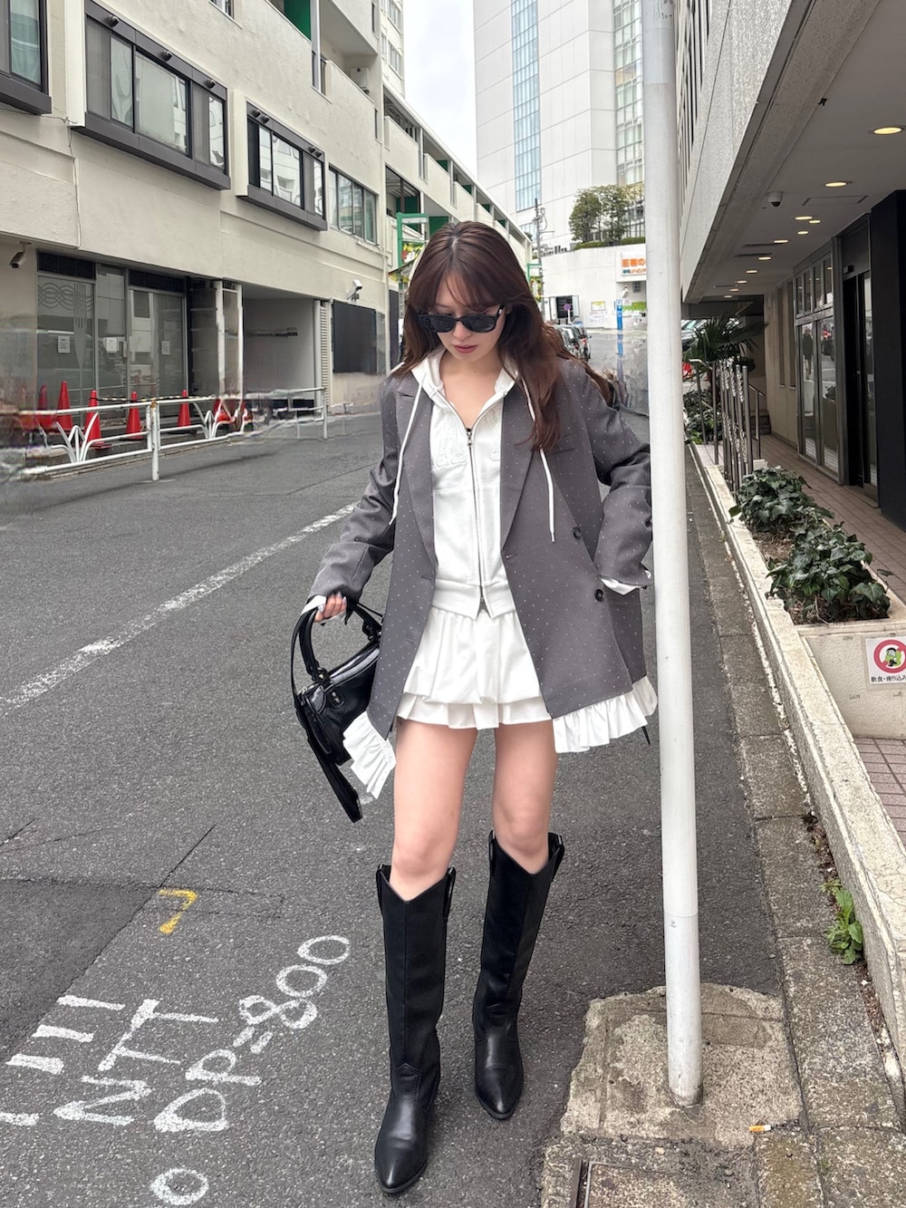 ホワイト系のパーカー、グレー系のテーラードジャケット、ホワイト系のスカートを着用したレディースの春コーディネートの4枚目の写真