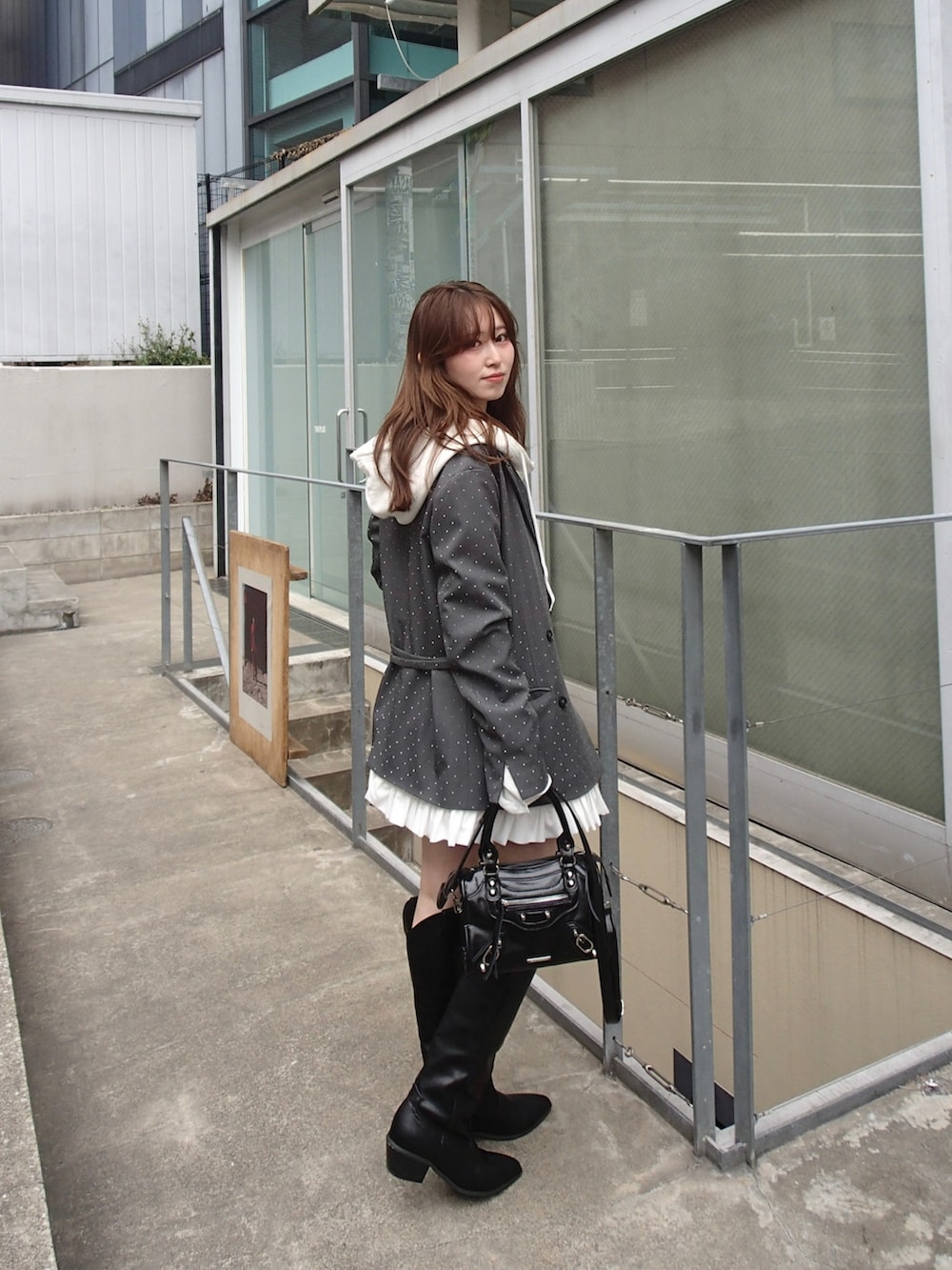 ホワイト系のパーカー、グレー系のテーラードジャケット、ホワイト系のスカートを着用したレディースの春コーディネートの3枚目の写真