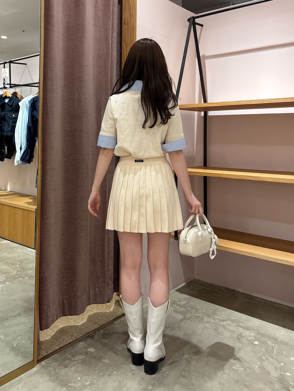 ホワイト系のニット/セーター、ホワイト系のスカート、ホワイト系のボストンバッグを着用したレディースの春コーディネートの3枚目の写真