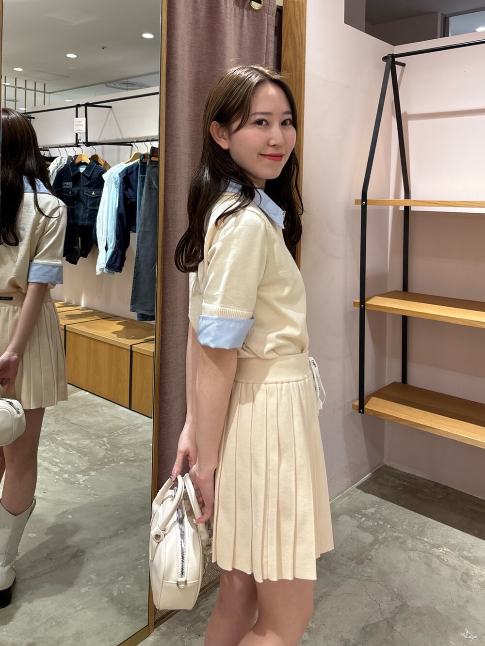 ホワイト系のニット/セーター、ホワイト系のスカート、ホワイト系のボストンバッグを着用したレディースの春コーディネートの2枚目の写真