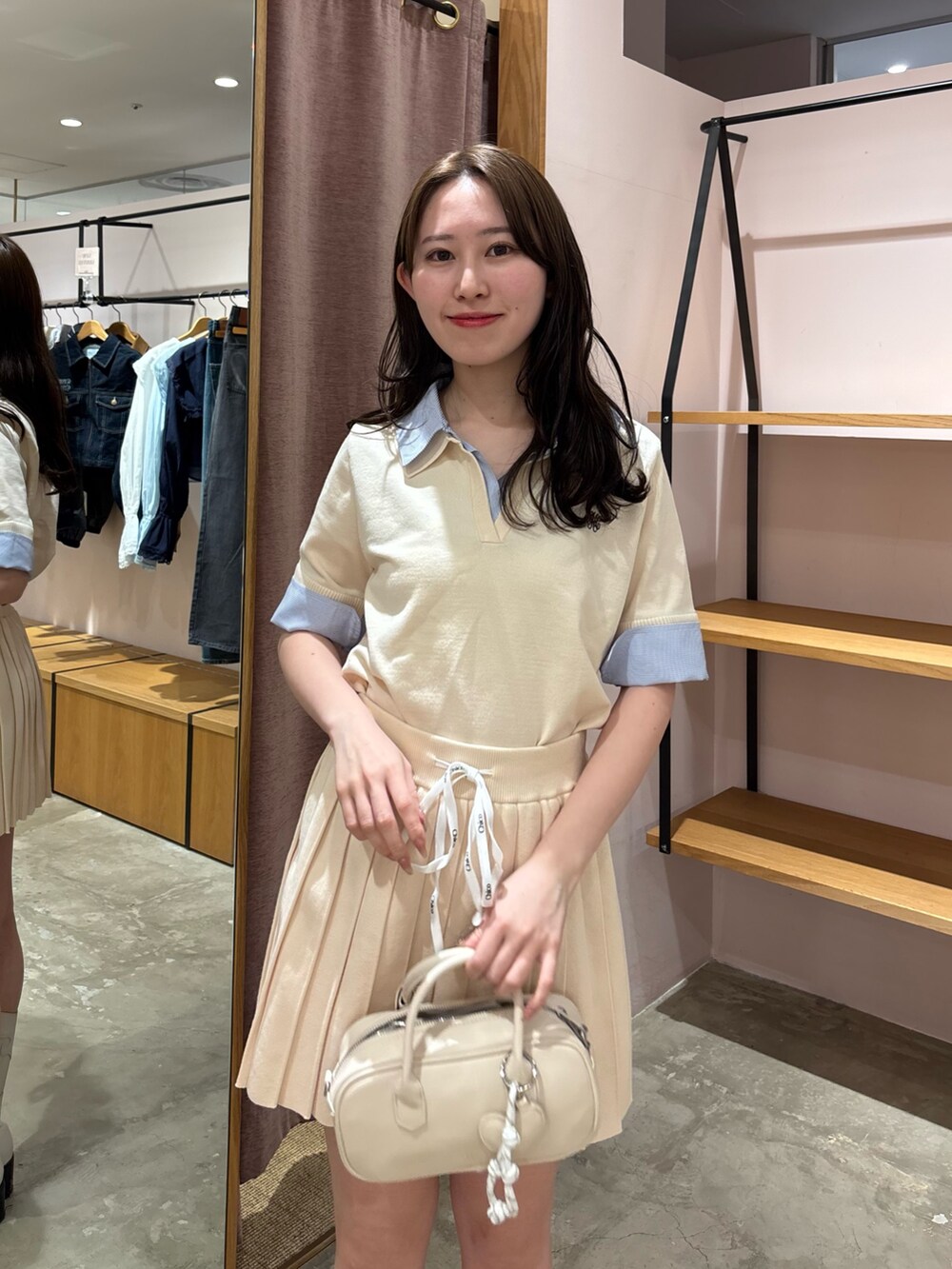 ホワイト系のニット/セーター、ホワイト系のスカート、ホワイト系のボストンバッグを着用したレディースの春コーディネートの4枚目の写真