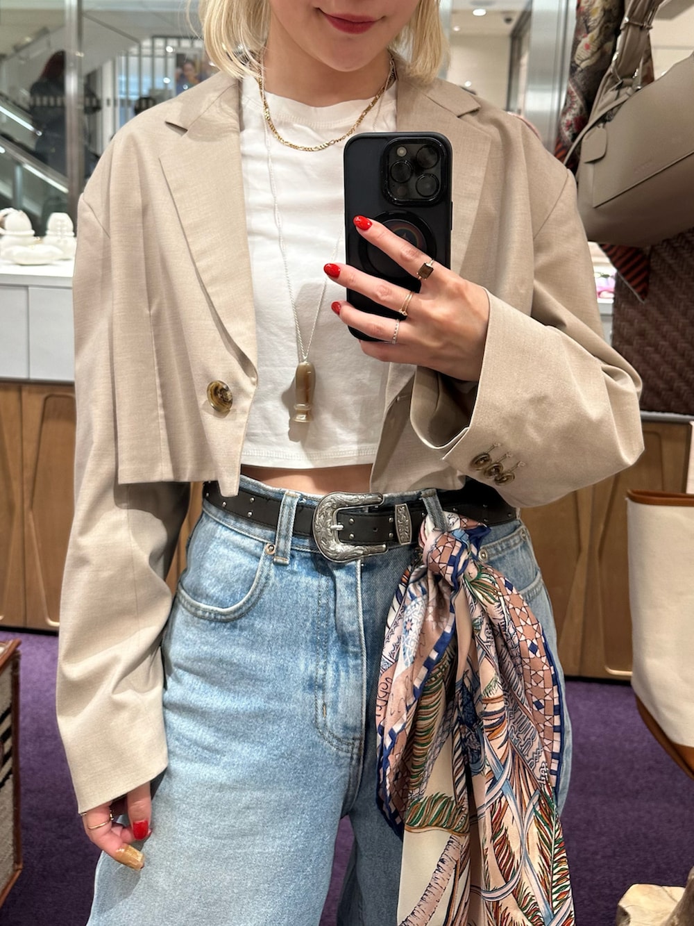 ブルー系のデニムパンツ、ベージュ系のテーラードジャケット、ホワイト系のTシャツ/カットソーを着用したレディースの春コーディネートの4枚目の写真