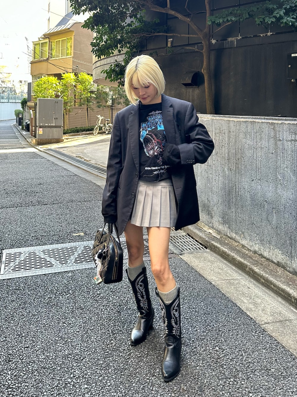 ブラック系のTシャツ/カットソー、ブラック系のテーラードジャケット、グレー系のスカートを着用したレディースの春コーディネートの2枚目の写真