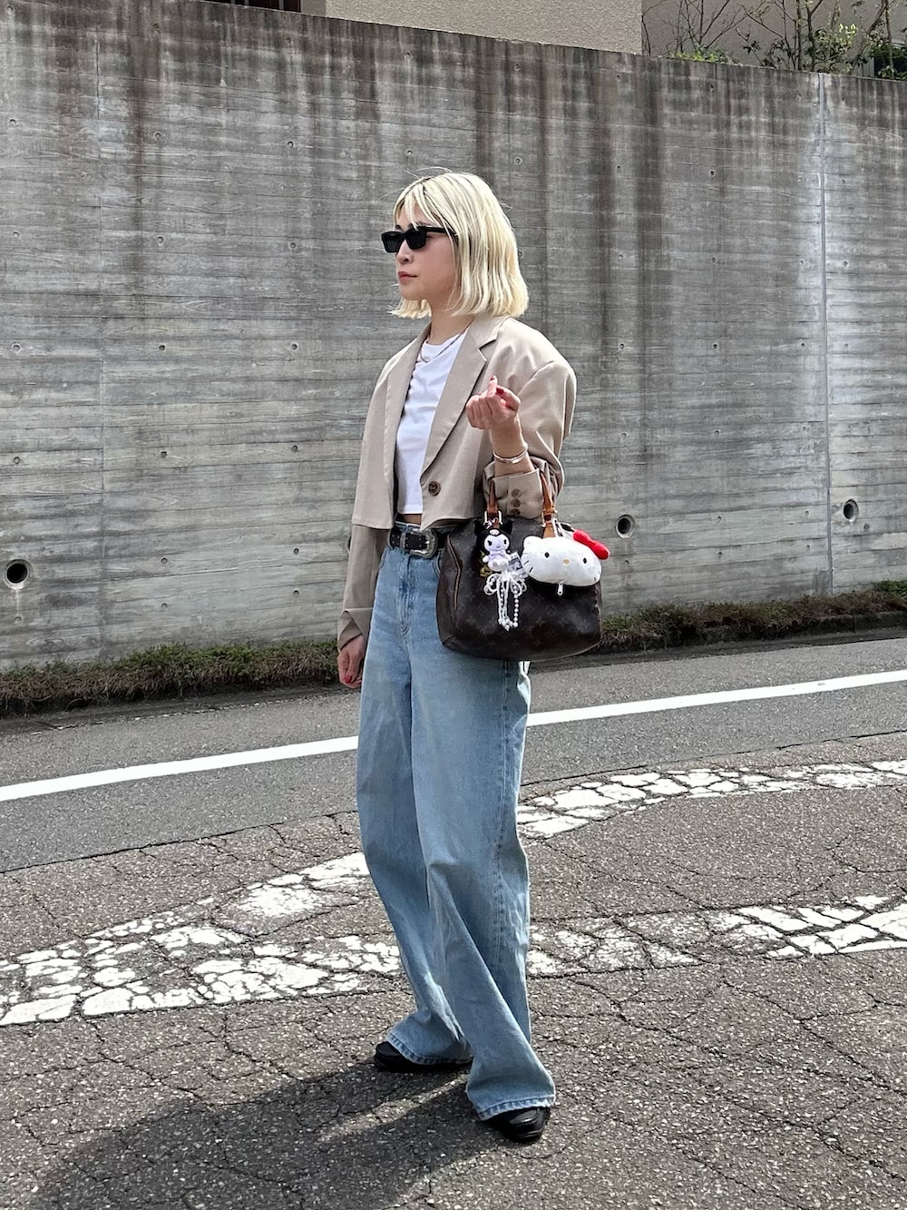 ブルー系のデニムパンツ、ベージュ系のテーラードジャケット、ホワイト系のTシャツ/カットソーを着用したレディースの春コーディネートの2枚目の写真