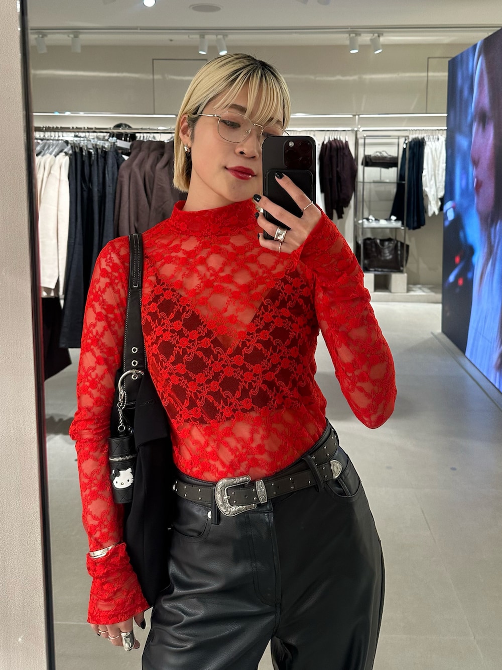 レッド系のTシャツ/カットソー、ブラック系のブーツを着用したレディースの秋コーディネートの3枚目の写真