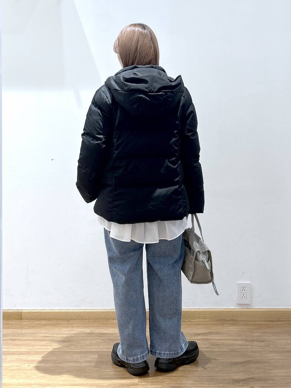 ブラック系のダウンジャケット/コート、グリーン系のボストンバッグ、ホワイト系のTシャツ/カットソーを着用したレディースの冬コーディネートの3枚目の写真