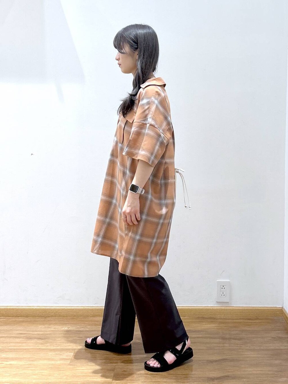 ホワイト系のタンクトップ、オレンジ系のワンピース、ホワイト系のショルダーバッグを着用したレディースの夏コーディネートの2枚目の写真