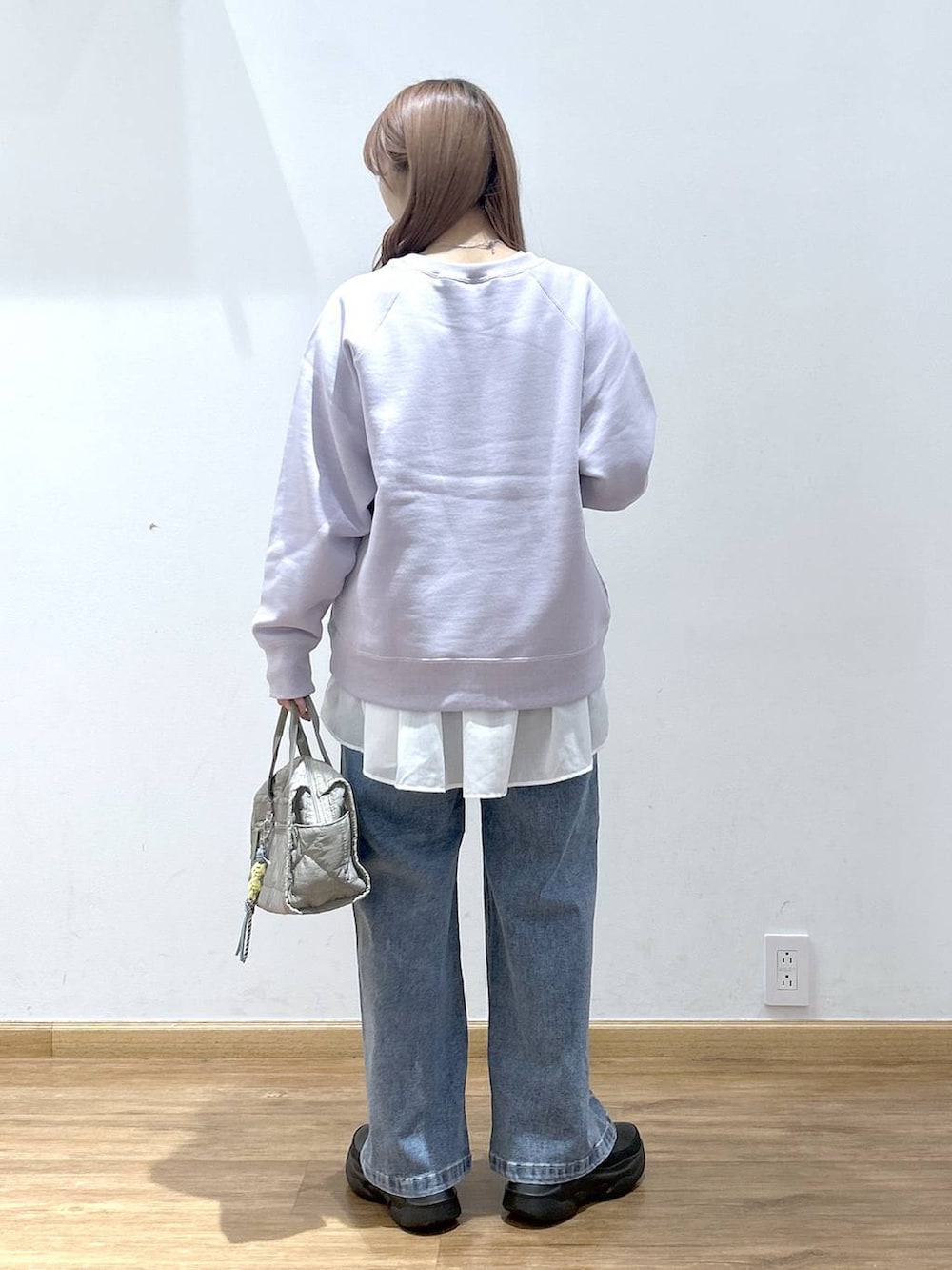 ブラック系のダウンジャケット/コート、グリーン系のボストンバッグ、ホワイト系のTシャツ/カットソーを着用したレディースの冬コーディネートの6枚目の写真