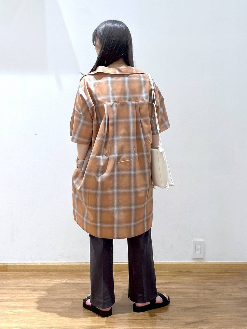 ホワイト系のタンクトップ、オレンジ系のワンピース、ホワイト系のショルダーバッグを着用したレディースの夏コーディネートの3枚目の写真