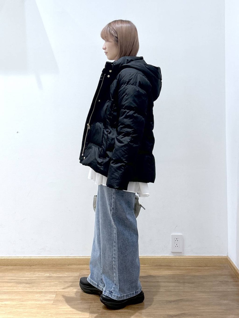 ブラック系のダウンジャケット/コート、グリーン系のボストンバッグ、ホワイト系のTシャツ/カットソーを着用したレディースの冬コーディネートの2枚目の写真