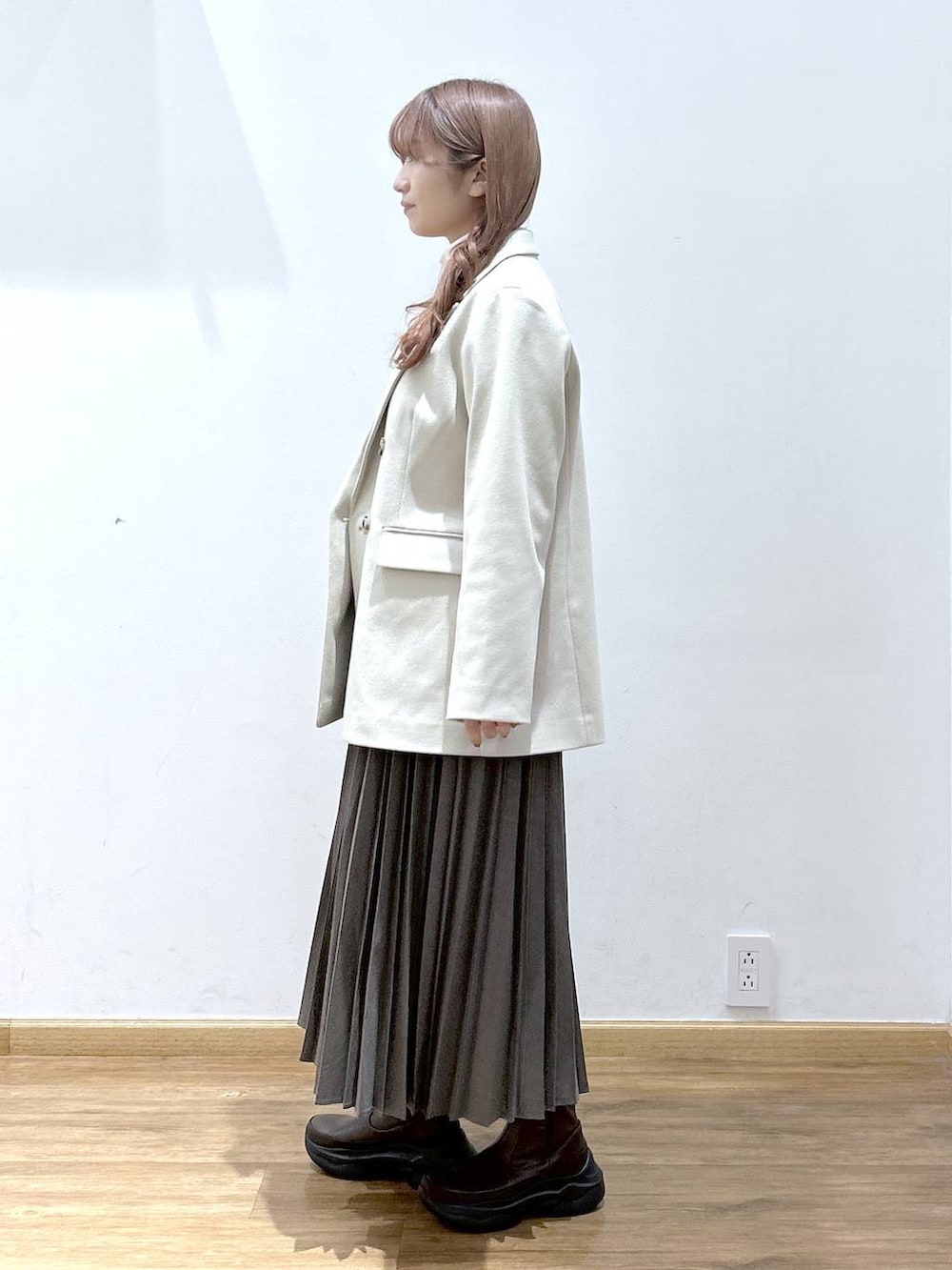 レッド系のカーディガン/ボレロ、ホワイト系のTシャツ/カットソー、ブラウン系のブーツを着用したレディースの秋コーディネートの2枚目の写真