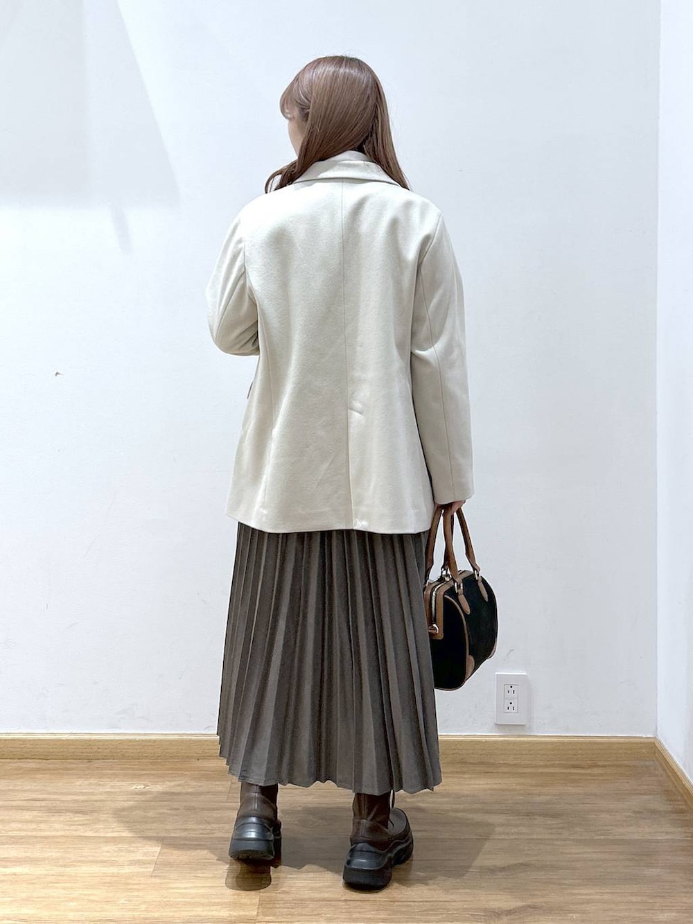 レッド系のカーディガン/ボレロ、ホワイト系のTシャツ/カットソー、ブラウン系のブーツを着用したレディースの秋コーディネートの3枚目の写真