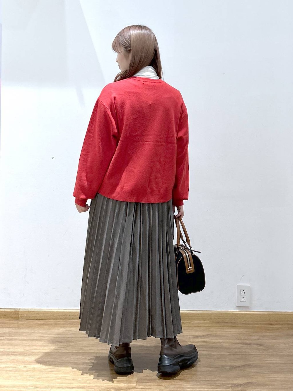 レッド系のカーディガン/ボレロ、ホワイト系のTシャツ/カットソー、ブラウン系のブーツを着用したレディースの秋コーディネートの6枚目の写真