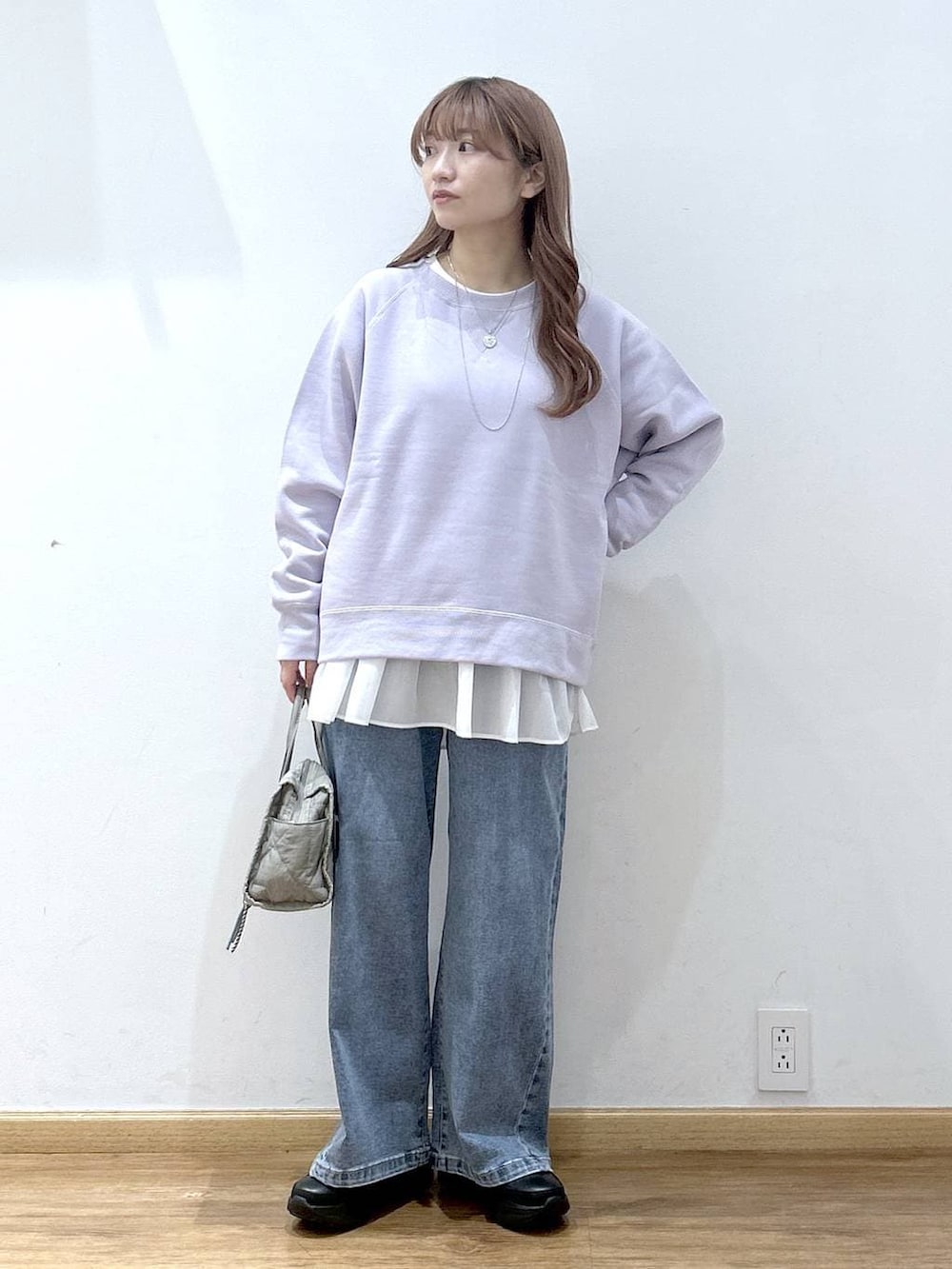 ブラック系のダウンジャケット/コート、グリーン系のボストンバッグ、ホワイト系のTシャツ/カットソーを着用したレディースの冬コーディネートの4枚目の写真