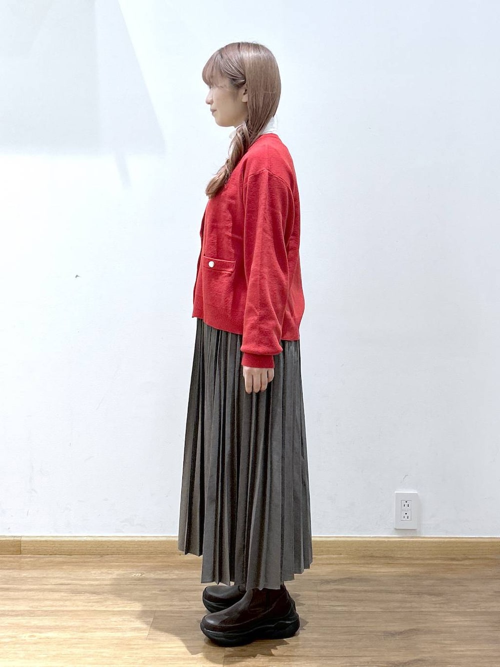 レッド系のカーディガン/ボレロ、ホワイト系のTシャツ/カットソー、ブラウン系のブーツを着用したレディースの秋コーディネートの5枚目の写真