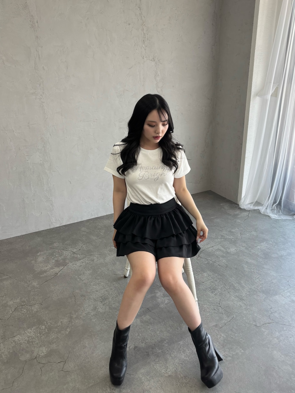 ブラック系のスカート、ホワイト系のTシャツ/カットソーを着用したレディースの夏コーディネートの3枚目の写真