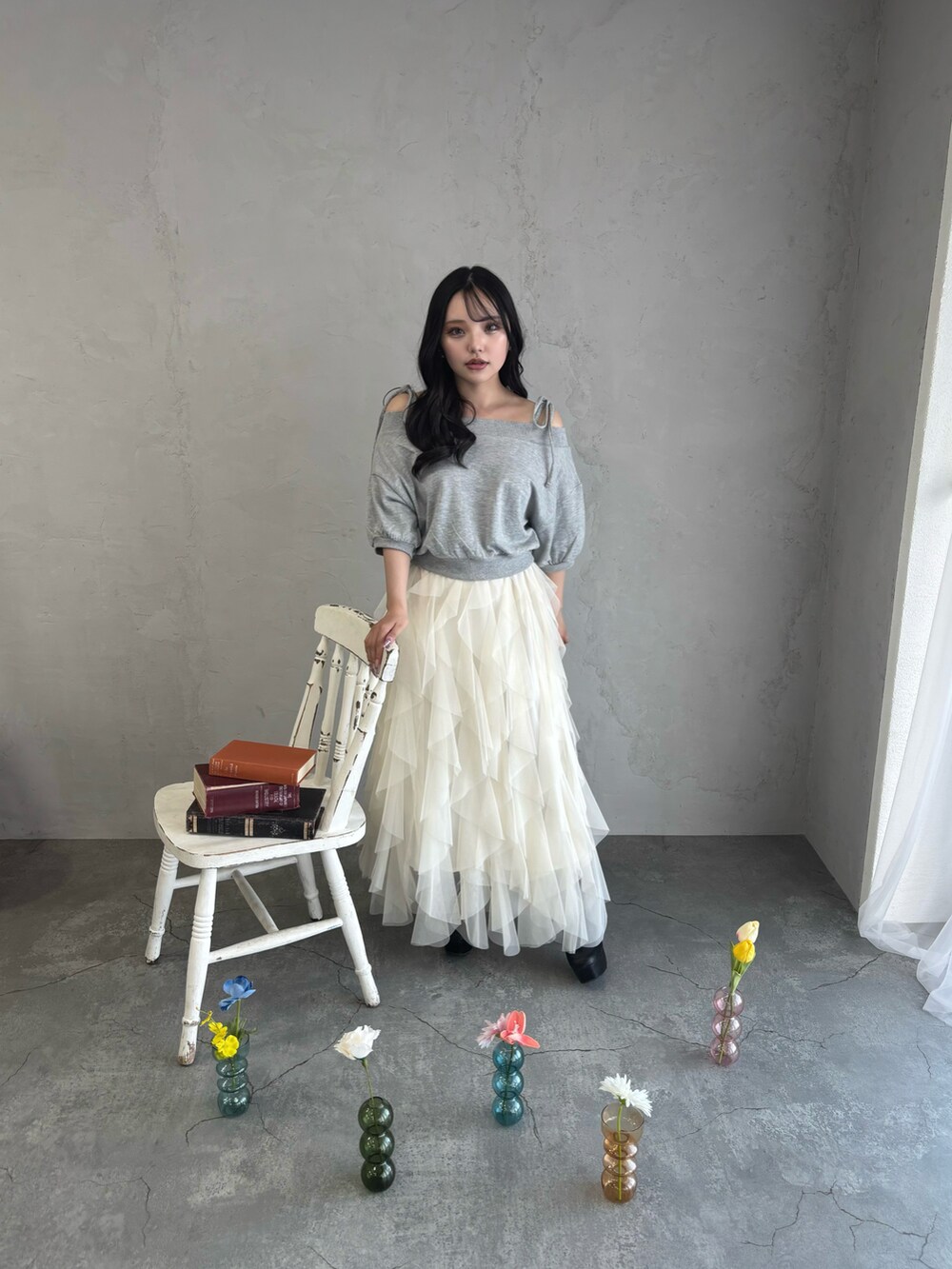 グレー系のスウェット、ホワイト系のスカートを着用したレディースの春コーディネートの2枚目の写真