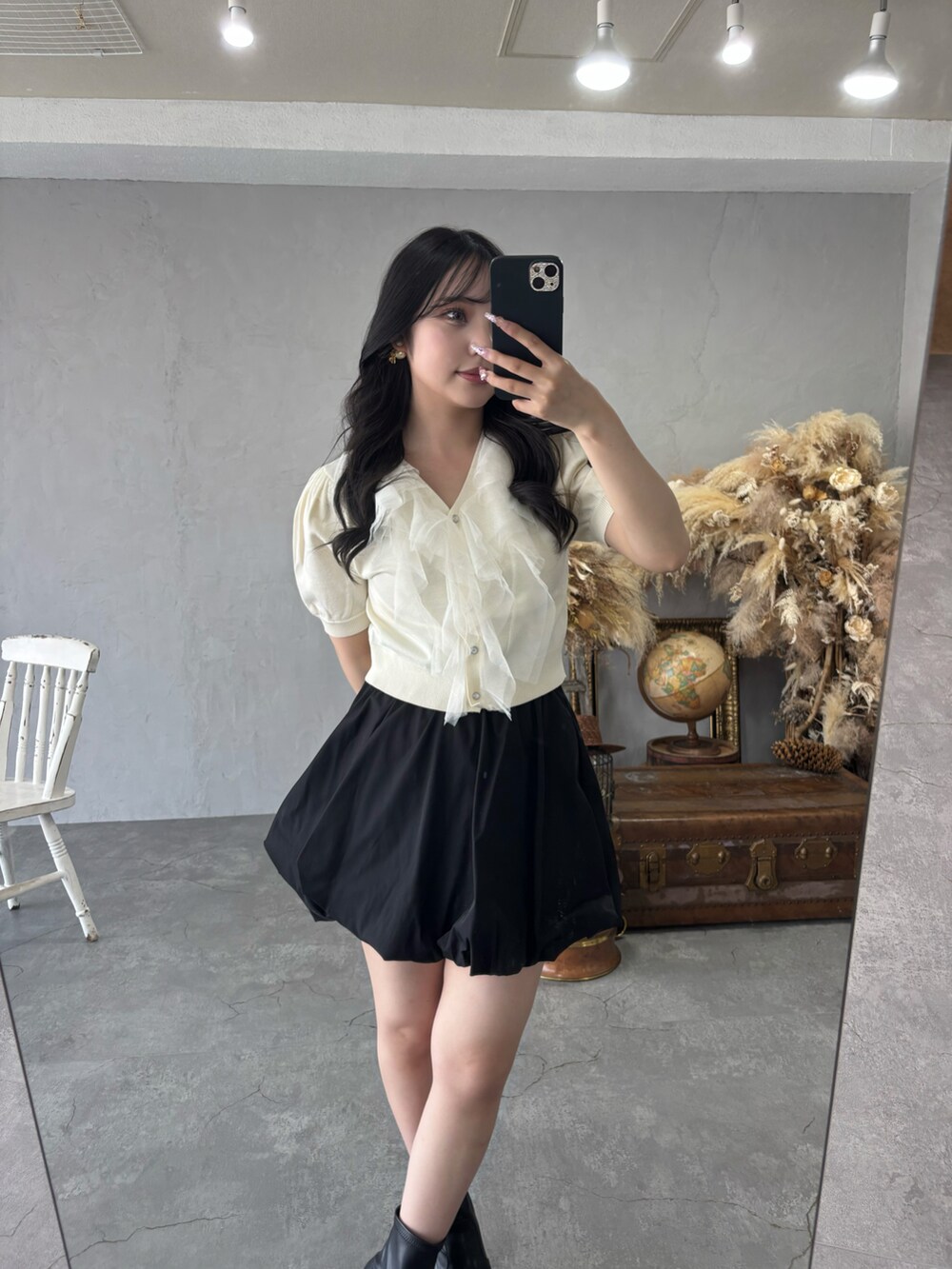 ホワイト系のカーディガン/ボレロ、ブラック系のスカートを着用したレディースの春コーディネートの2枚目の写真