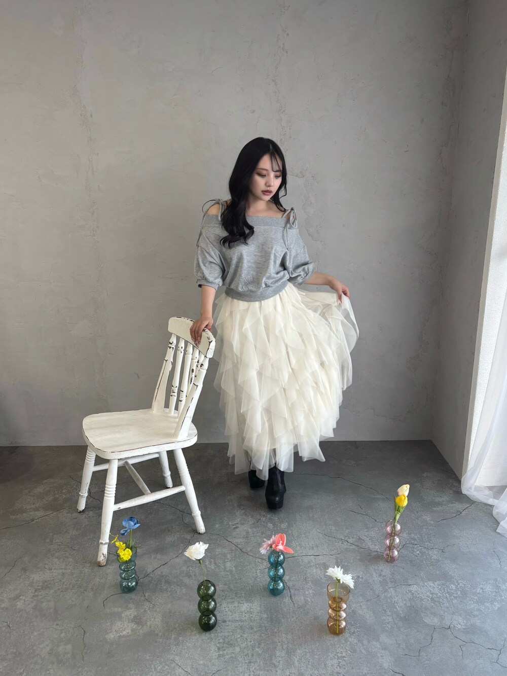 グレー系のスウェット、ホワイト系のスカートを着用したレディースの春コーディネートの4枚目の写真