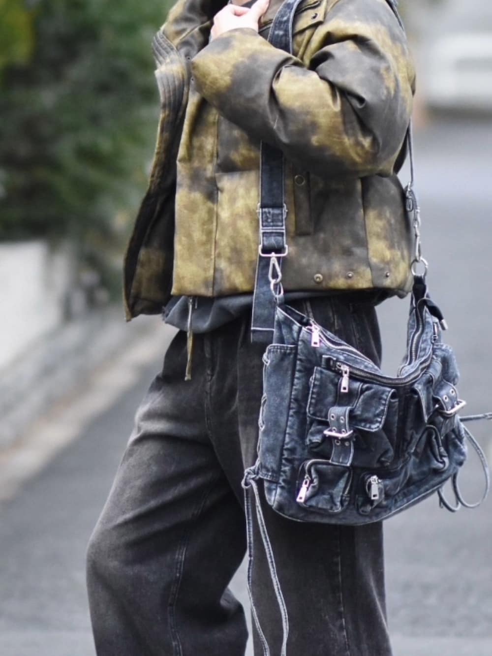 ブラック系のデニムパンツ、ブラウン系のダウンジャケット/コート、グレー系のスニーカーを着用したメンズの冬コーディネートの2枚目の写真