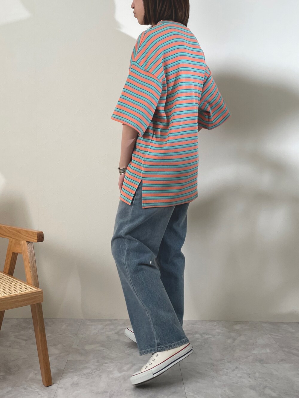 オレンジ系のTシャツ/カットソーを着用したレディースの春コーディネートの2枚目の写真