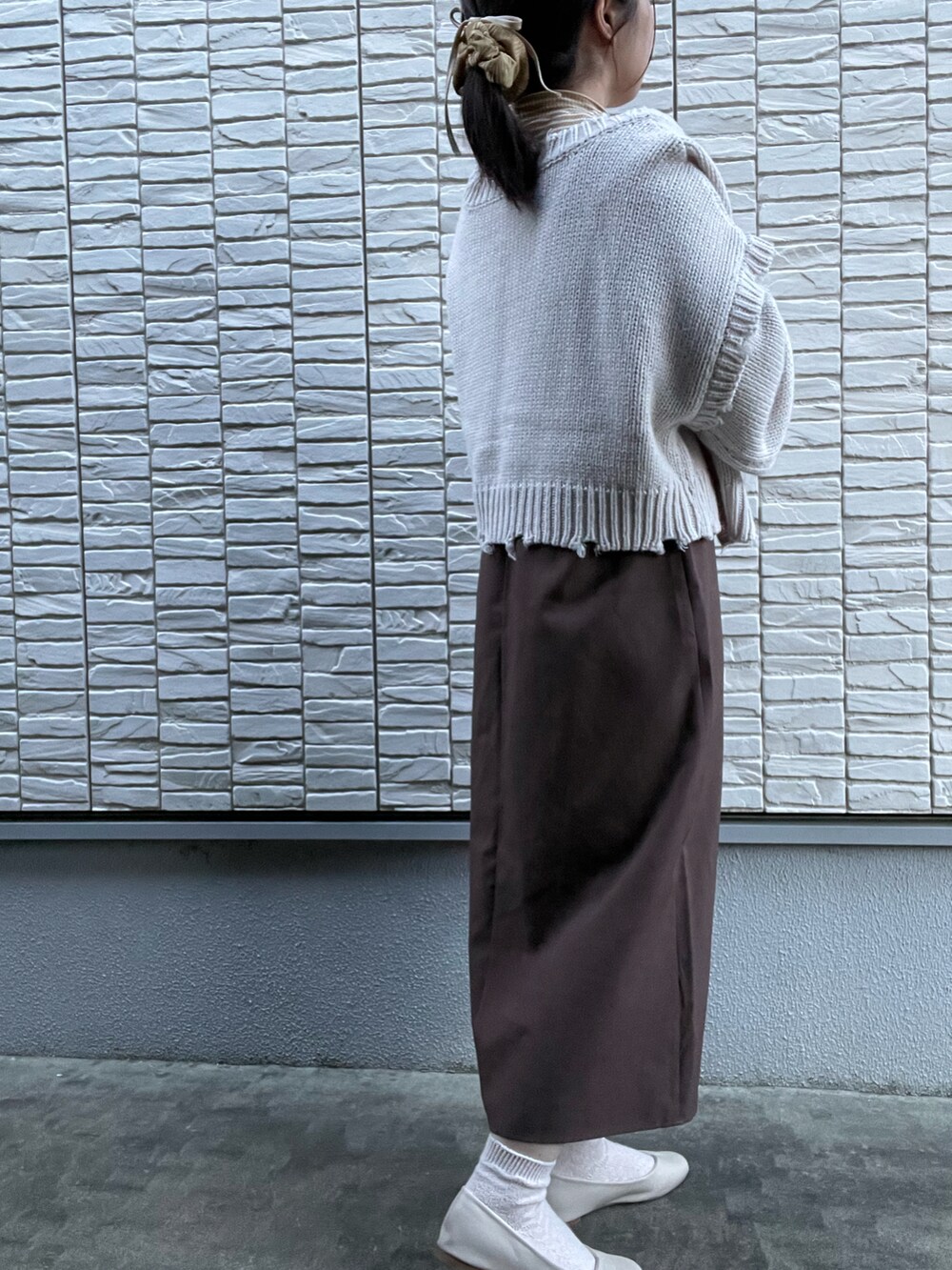 ブラウン系のワンピース/ドレス、ホワイト系のカーディガン/ボレロ、イエロー系のトップスを着用したレディースの春コーディネートの2枚目の写真