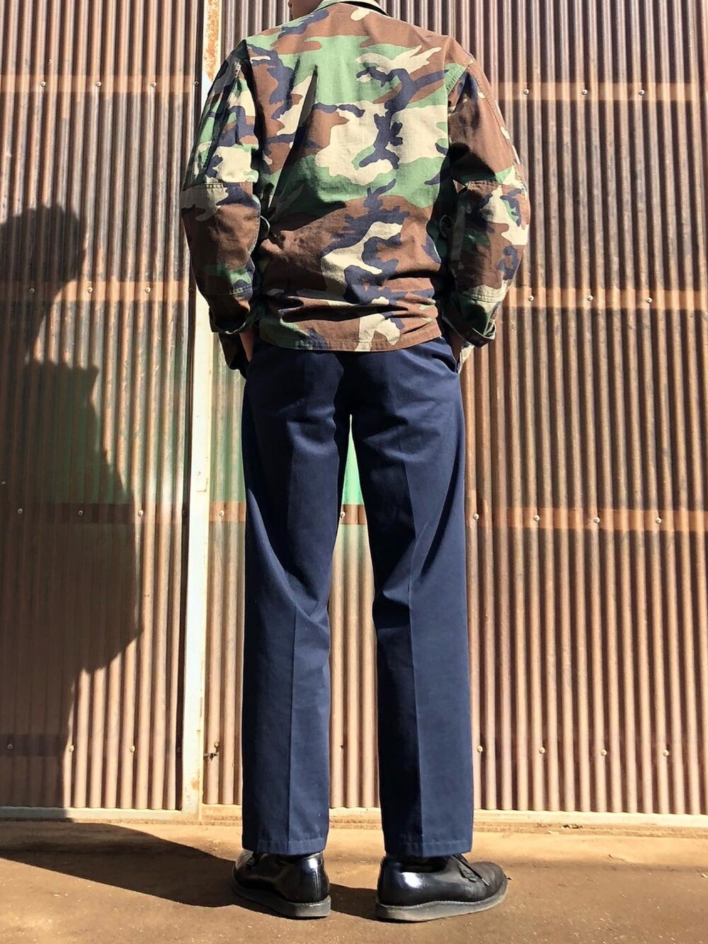 グリーン系のミリタリージャケット、ブルー系のデニムジャケット、ブルー系のスラックスを着用したメンズの秋コーディネートの2枚目の写真