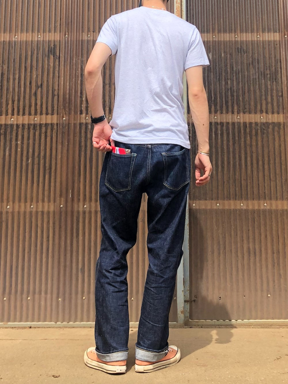 グレー系のTシャツ/カットソー、ブルー系のデニムパンツ、ピンク系のスニーカーを着用したメンズの夏コーディネートの2枚目の写真