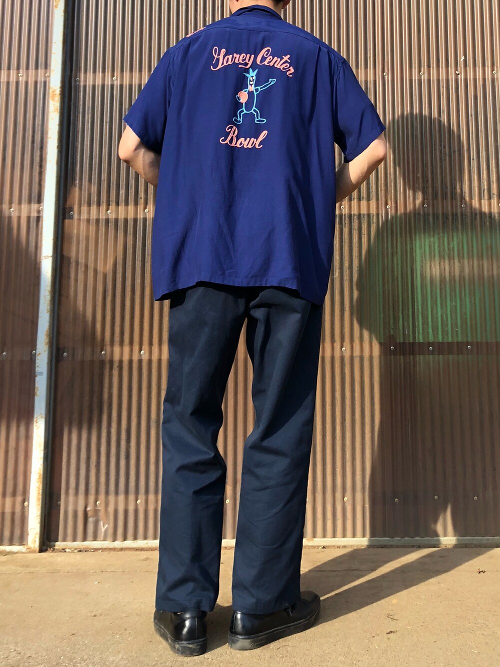 ブラック系のシューズ、ブルー系のチノパンツ、ブルー系のシャツ/ブラウスを着用したメンズの夏コーディネートの2枚目の写真