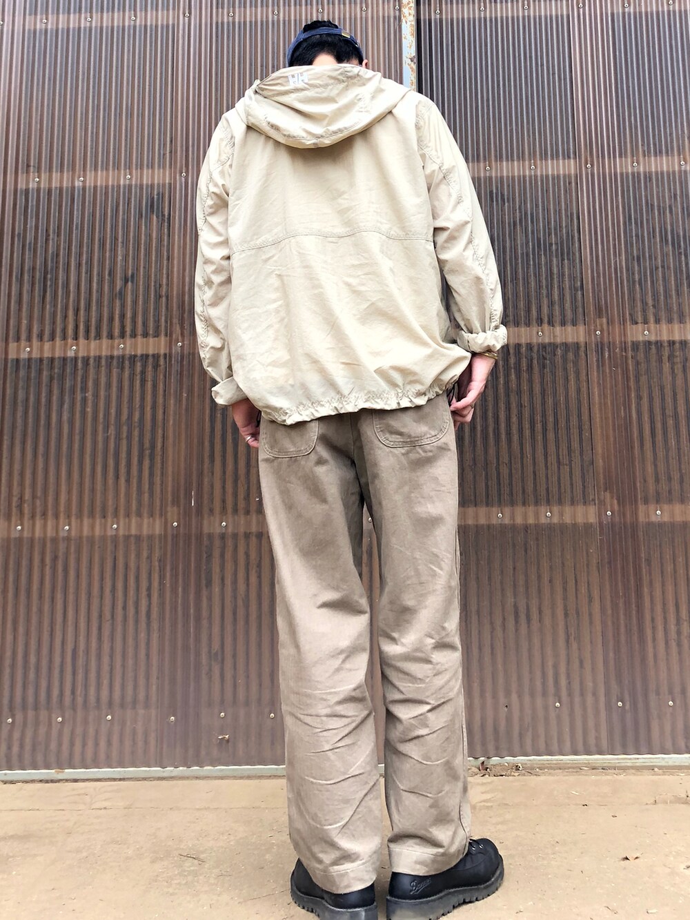 ベージュ系のナイロンジャケット、ホワイト系のTシャツ/カットソー、グリーン系のその他パンツを着用したメンズの秋コーディネートの2枚目の写真