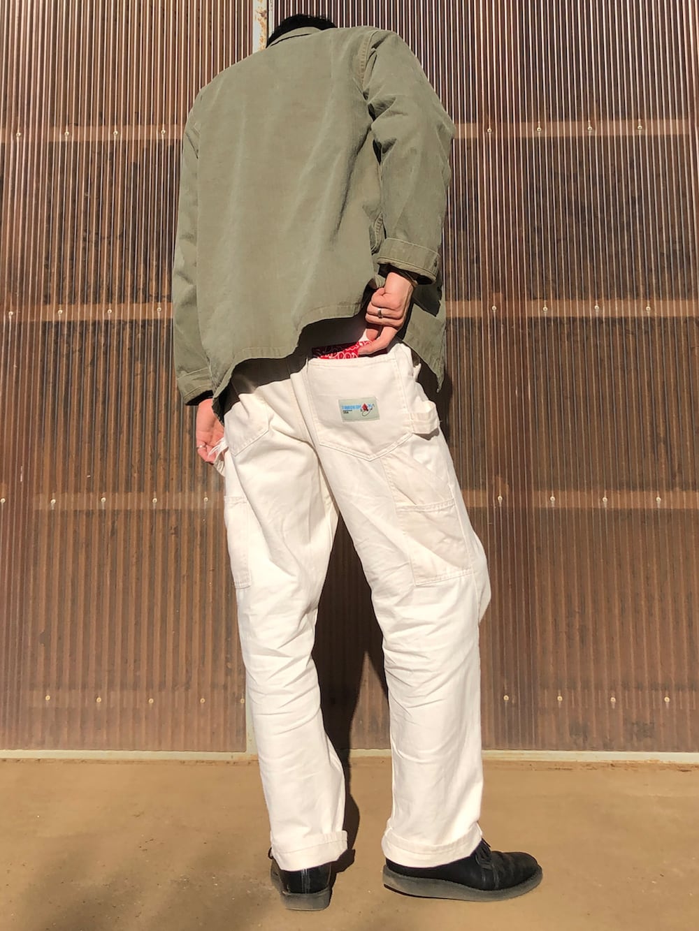 ベージュ系のその他パンツ、ブラック系のブーツ、グリーン系のニット/セーターを着用したメンズの冬コーディネートの2枚目の写真