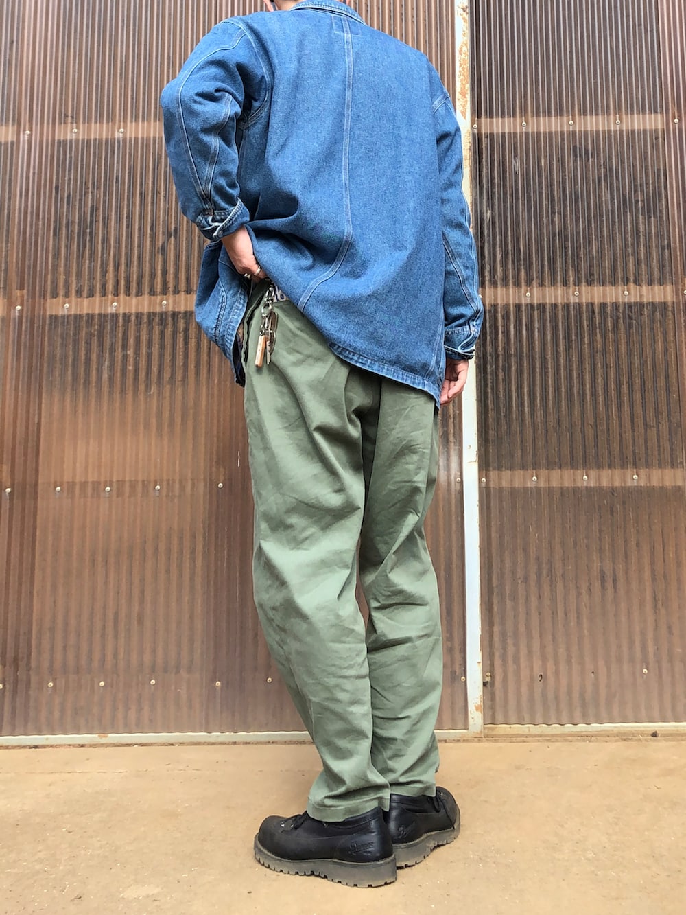 ブラック系のブーツ、グリーン系のチノパンツ、ブルー系のデニムジャケットを着用したメンズの春コーディネートの2枚目の写真