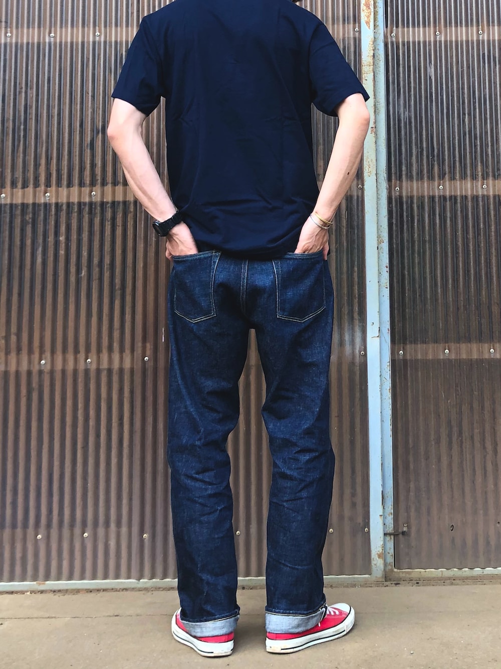 レッド系のスニーカー、ブルー系のデニムパンツ、ブルー系のTシャツ/カットソーを着用したメンズの夏コーディネートの2枚目の写真
