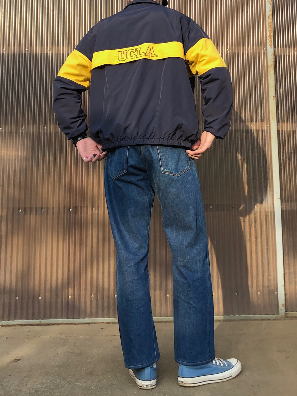 ブルー系のスウェット、ブルー系のナイロンジャケット、ブルー系のデニムパンツを着用したメンズの春コーディネートの2枚目の写真