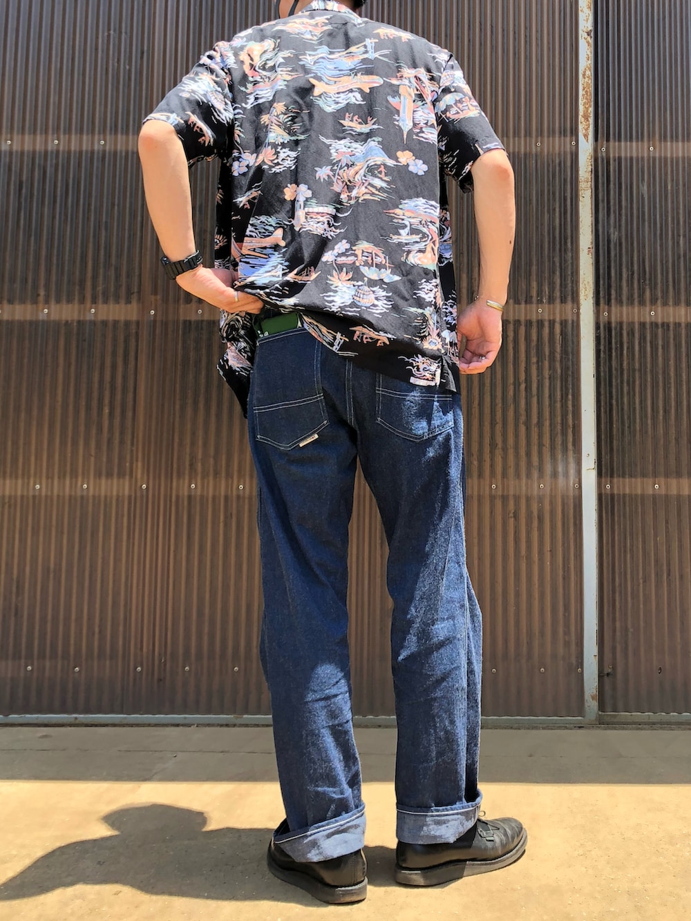 ブラック系のブーツ、ブルー系のデニムパンツ、グリーン系のTシャツ/カットソーを着用したメンズの夏コーディネートの2枚目の写真