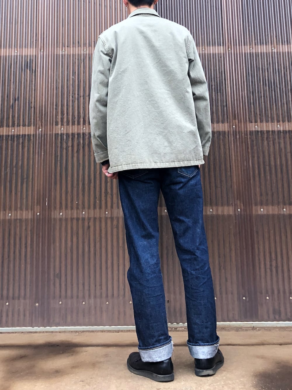 グリーン系のミリタリージャケット、ブルー系のシャツ/ブラウス、ブルー系のデニムパンツを着用したメンズの秋コーディネートの2枚目の写真