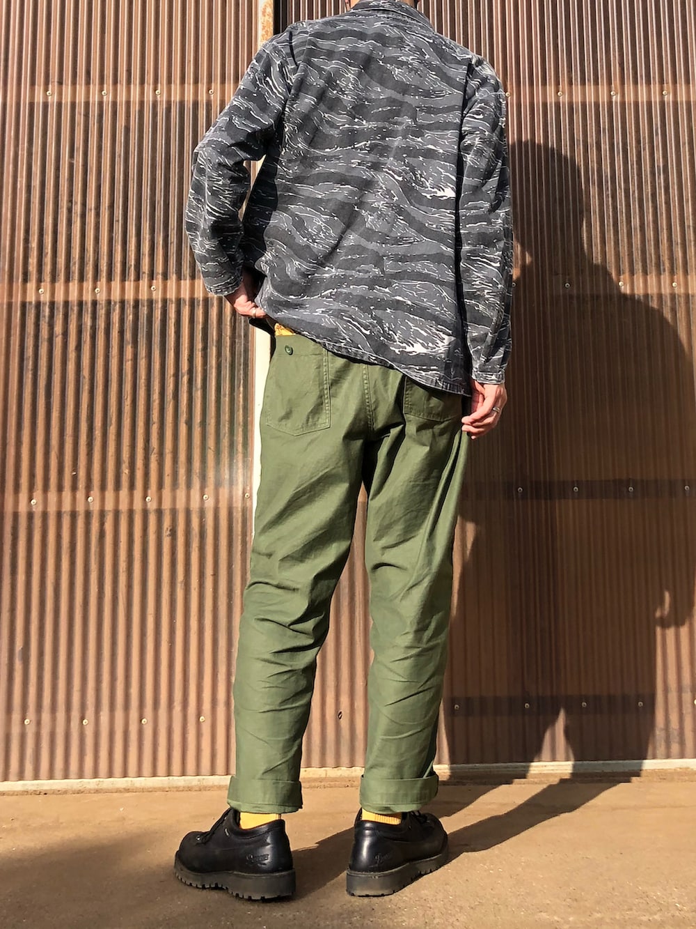 ブラック系のブーツ、グリーン系のその他パンツ、ホワイト系のTシャツ/カットソーを着用したメンズの春コーディネートの2枚目の写真