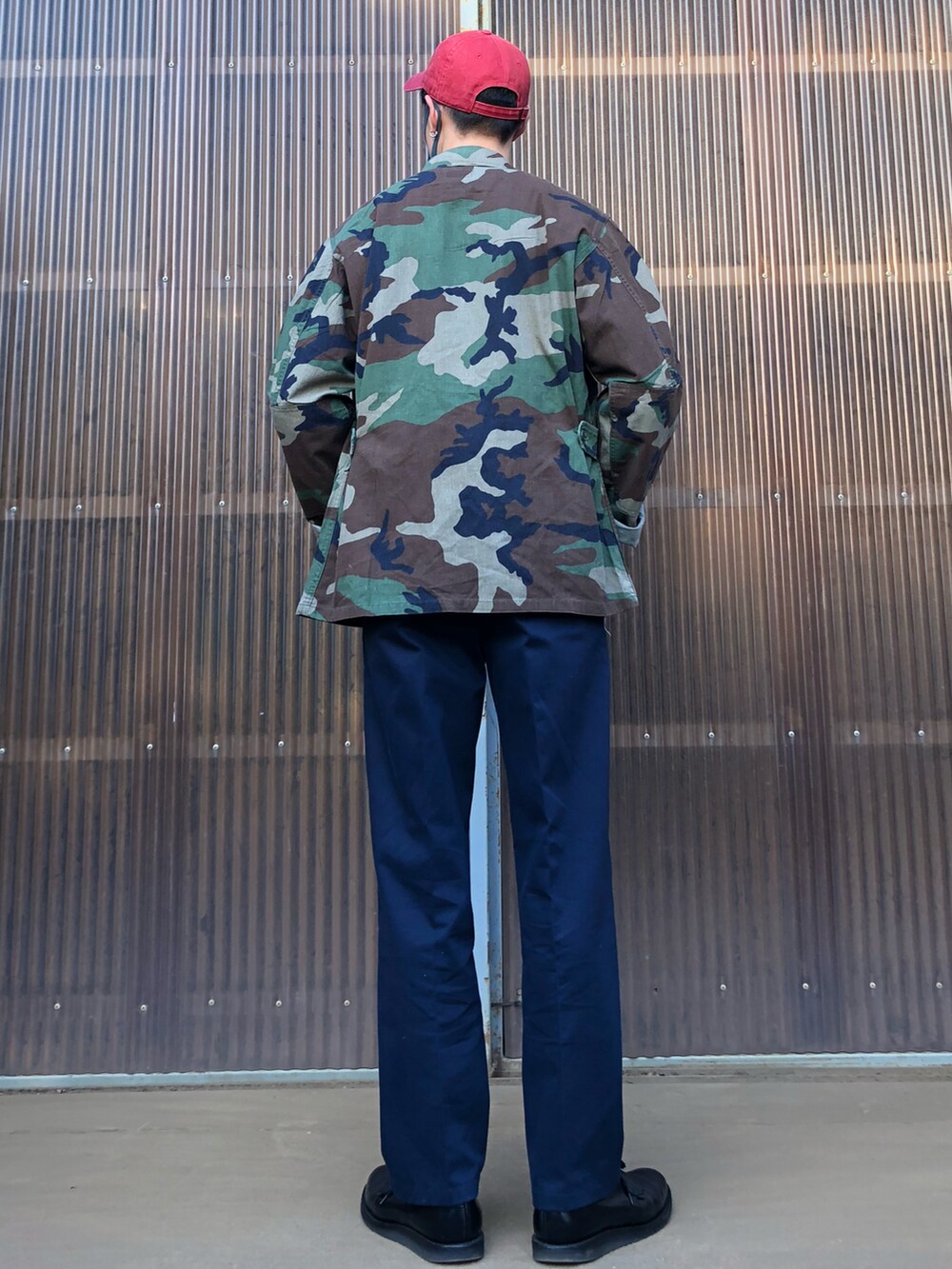 グリーン系のミリタリージャケット、ブルー系のスウェット、ブルー系のスラックスを着用したメンズの秋コーディネートの2枚目の写真